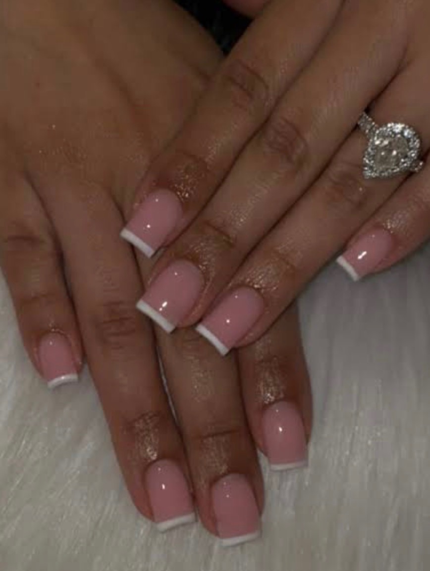 Short square pink French manicure with crisp white tips and a heart-shaped ring