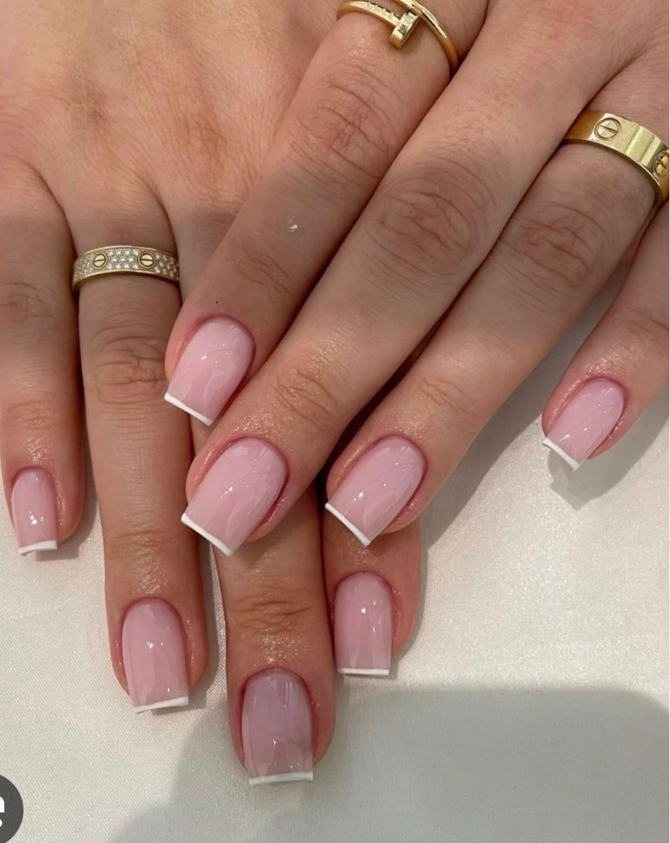 Glossy pale pink square nails with fine white French tips and gold rings
